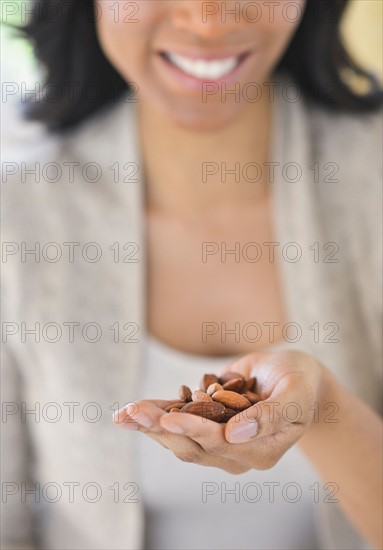 Close-up of woman holding almonds.