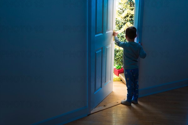 Boy (4-5) peeking through doorway.