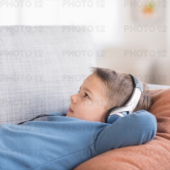 Boy (4-5) listening to music on headphones.