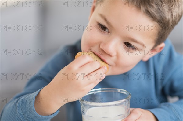 Boy (4-5) eating cookie.