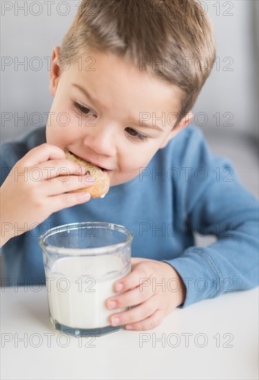 Boy (4-5) eating cookie.