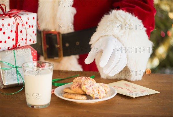 Santa claus reaching for cookie.