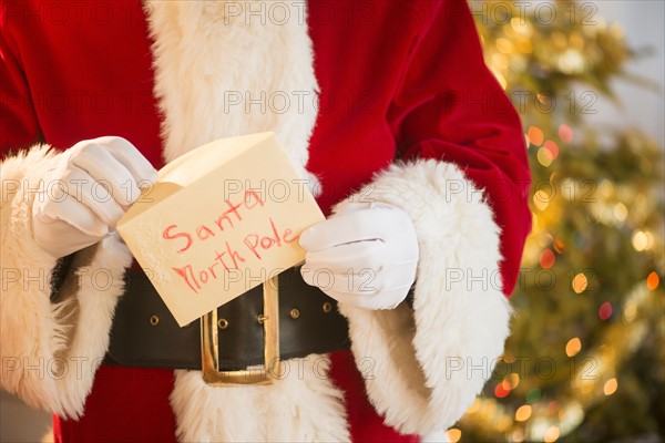 Santa claus holding letter.