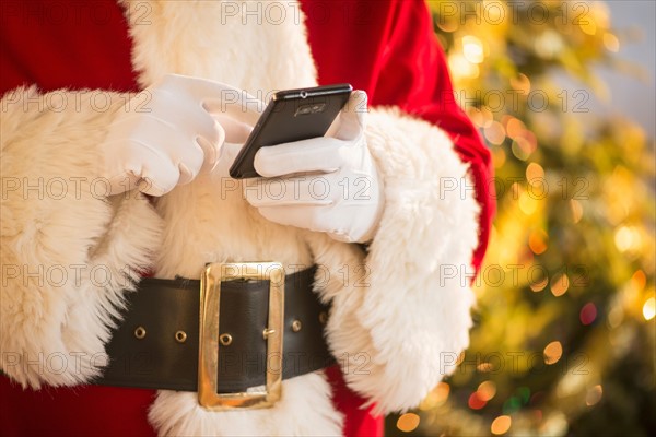 Santa claus holding cell phone.