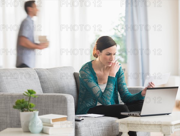 Woman using laptop to pay bills.