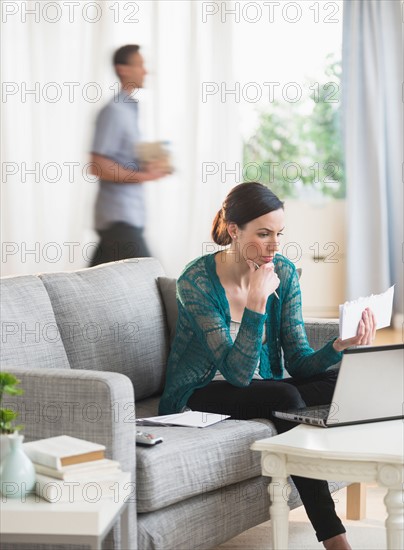 Woman using laptop to pay bills.