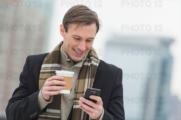 Man in winter clothes looking at phone.