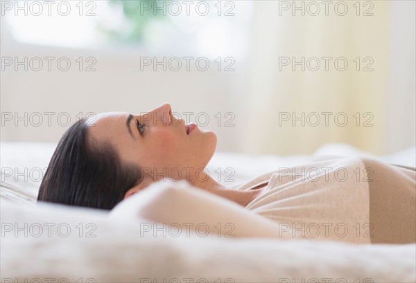 Woman lying on bed.