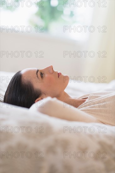Woman lying on bed.