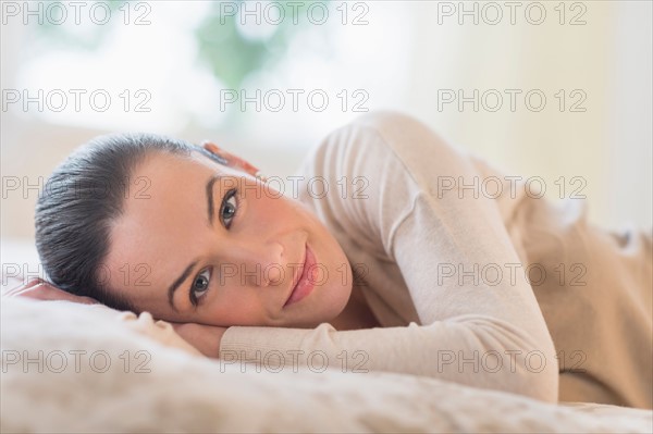 Portrait of woman lying on bed.