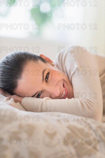 Portrait of woman lying on bed.