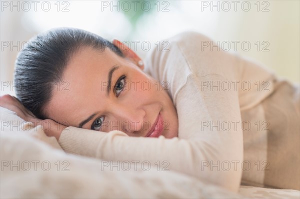 Portrait of woman lying on bed.