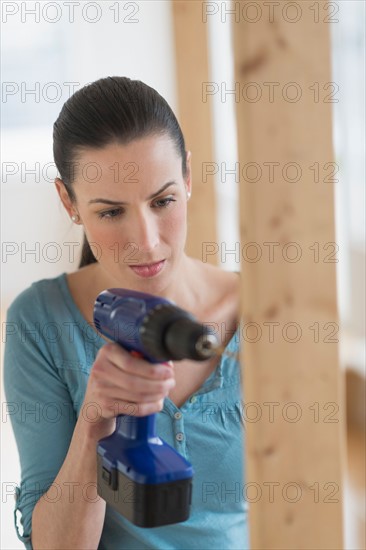 Woman using hand drill.