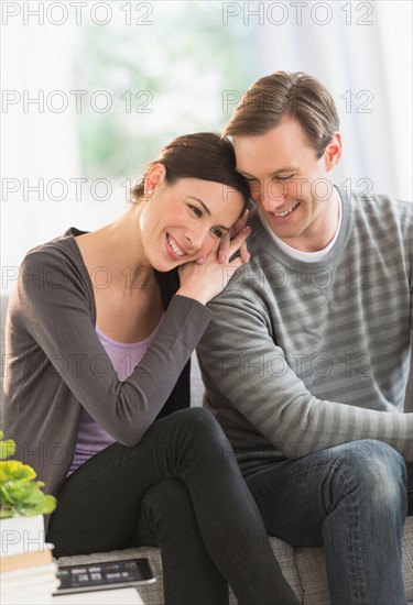 Portrait of couple sitting on sofa.