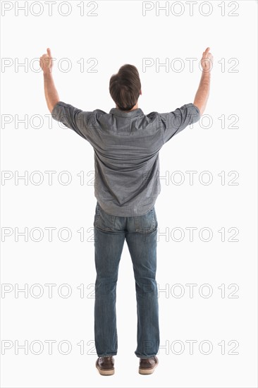 Rear view of man raising arms.