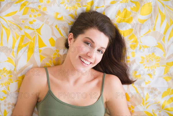 Portrait of beautiful woman lying on bed.