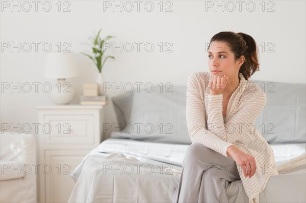 Woman sitting on bed.