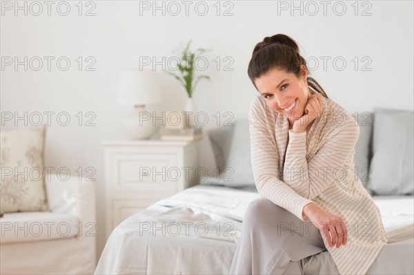 Woman sitting on bed.