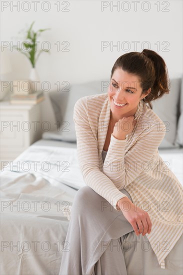 Woman sitting on bed.