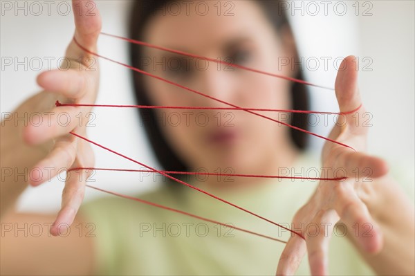 Woman playing cat's cradle.