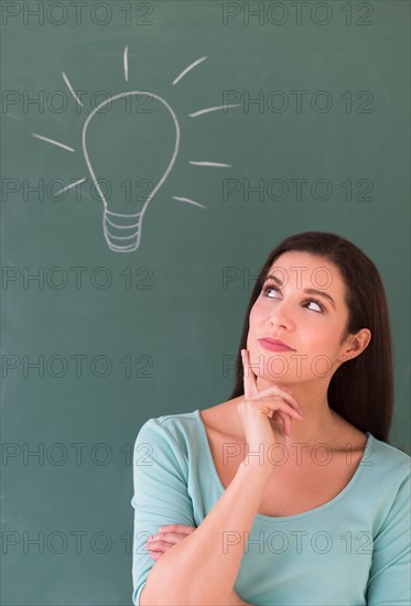 Woman in front of blackboard.