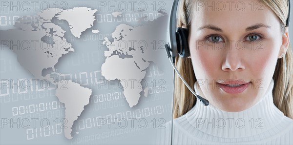 Woman with headset with world map in background.