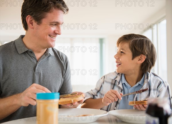 Father and son (8-9) eating lunch