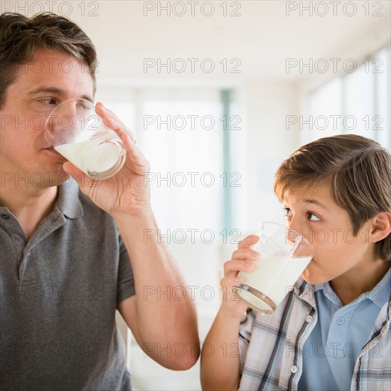 Father and son (8-9) drinking milk