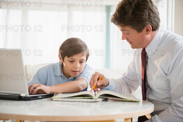 Father and son (8-9) doing homework