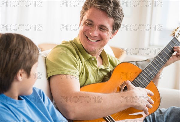Father and son (8-9) playing guitar