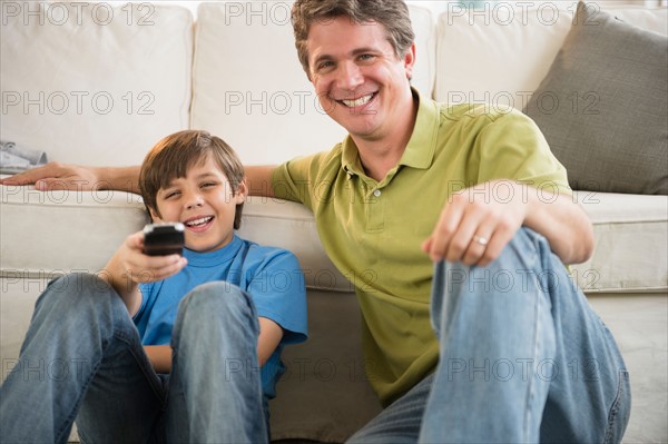 Father and son (8-9) watching television