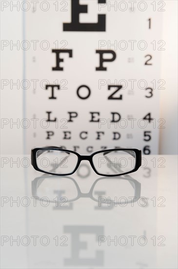 Studio shot of eyeglasses and eye chart