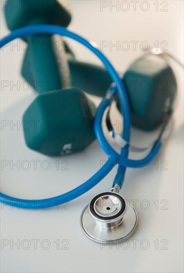 Studio shot of stethoscope and dumbbells