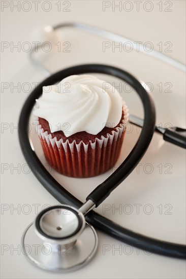 Studio shot of stethoscope and cupcake