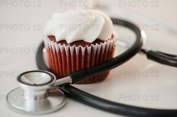 Studio shot of stethoscope and cupcake