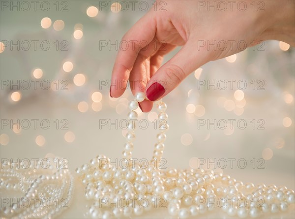 Hand holding pearl necklace