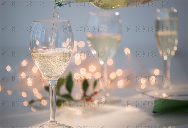 Pouring white wine into glasses