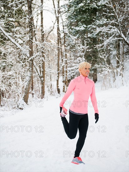 Woman exercising in winter forest