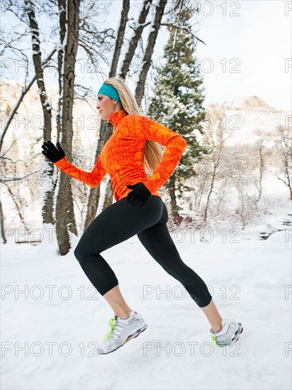 Woman jogging in winter forest