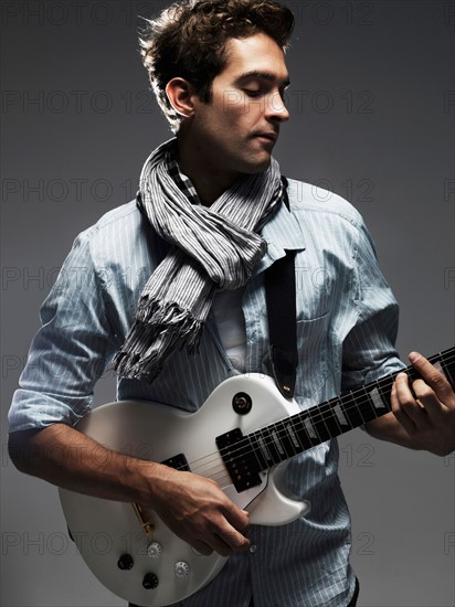 Studio shot of man playing electric guitar