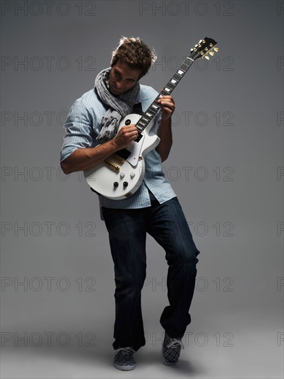 Studio shot of man playing electric guitar