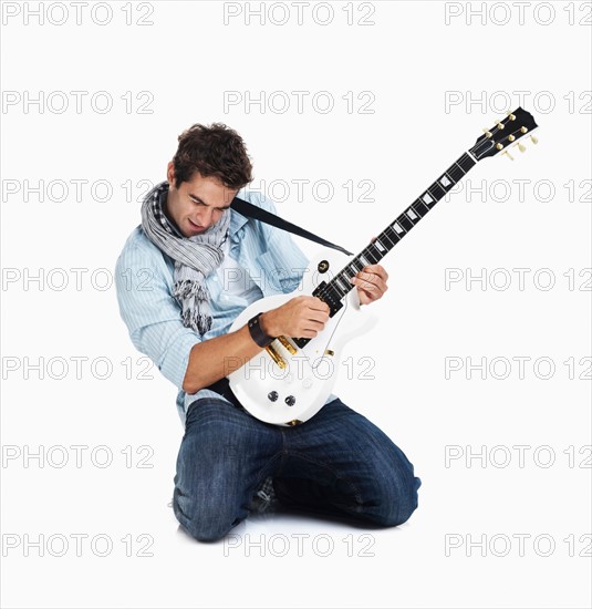 Studio shot of man playing electric guitar