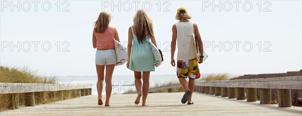 Rear view of people walking towards beach