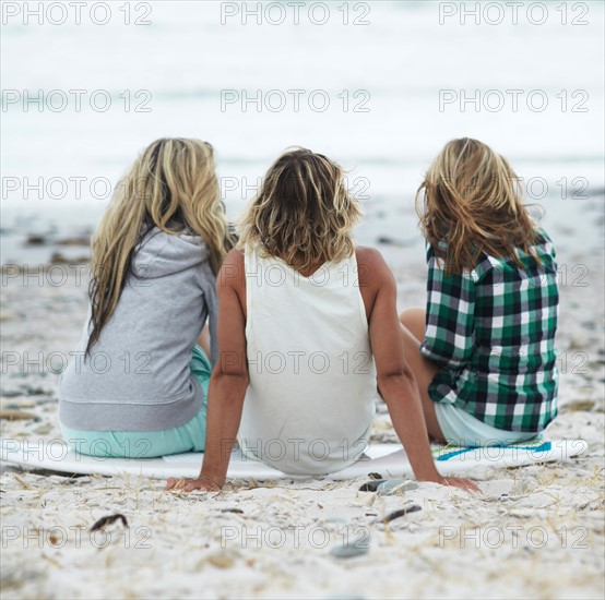 Rear view of people sitting on beach