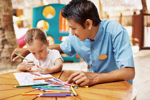 Portrait of teacher and girl (3) at table