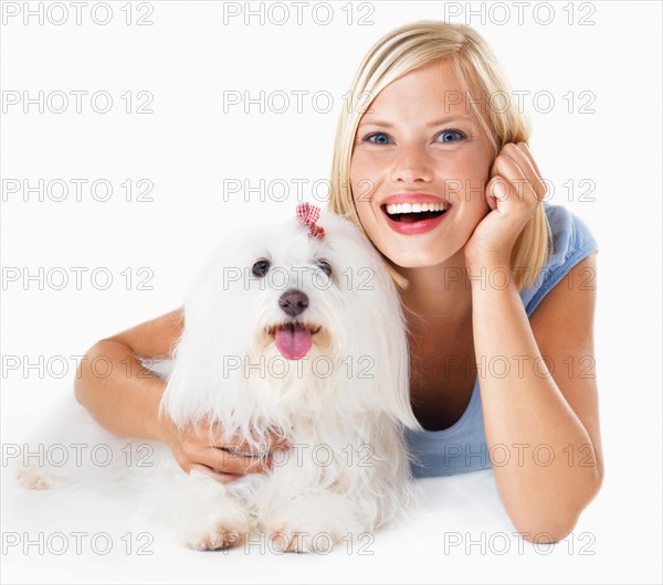 Studio Shot, Portrait of young woman lying down, hugging her dog