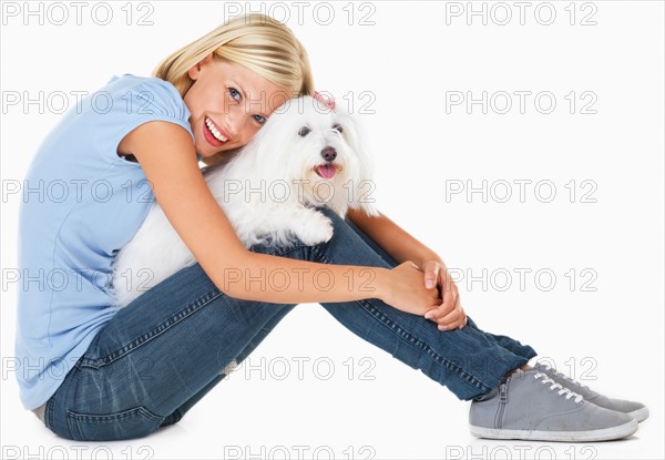 Studio Shot, Portrait of young woman sitting and holding dog