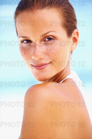 Portrait of young woman looking over shoulder