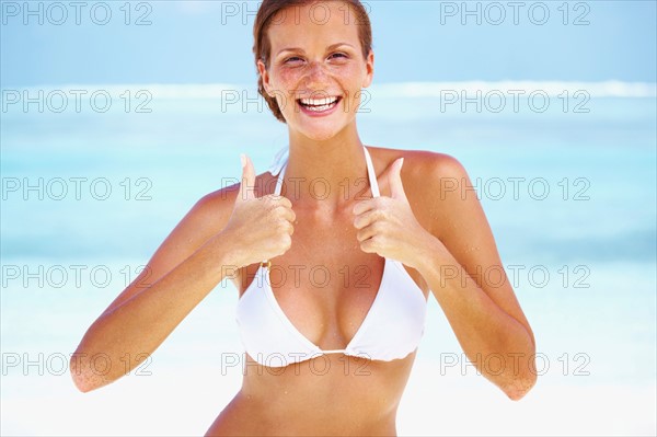 Portrait of young woman giving thumbs up