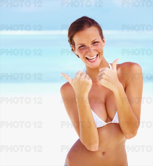 Portrait of young woman giving thumbs up